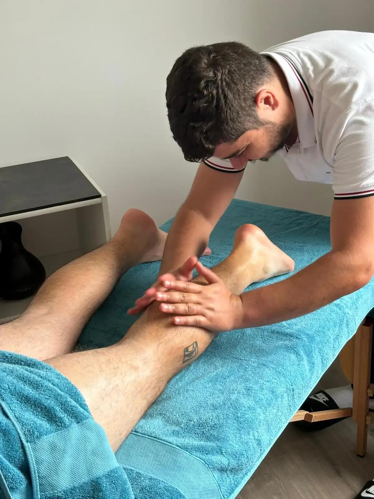 Massage des mollets sur un client allongé sur une serviette turquoise, spa MCH